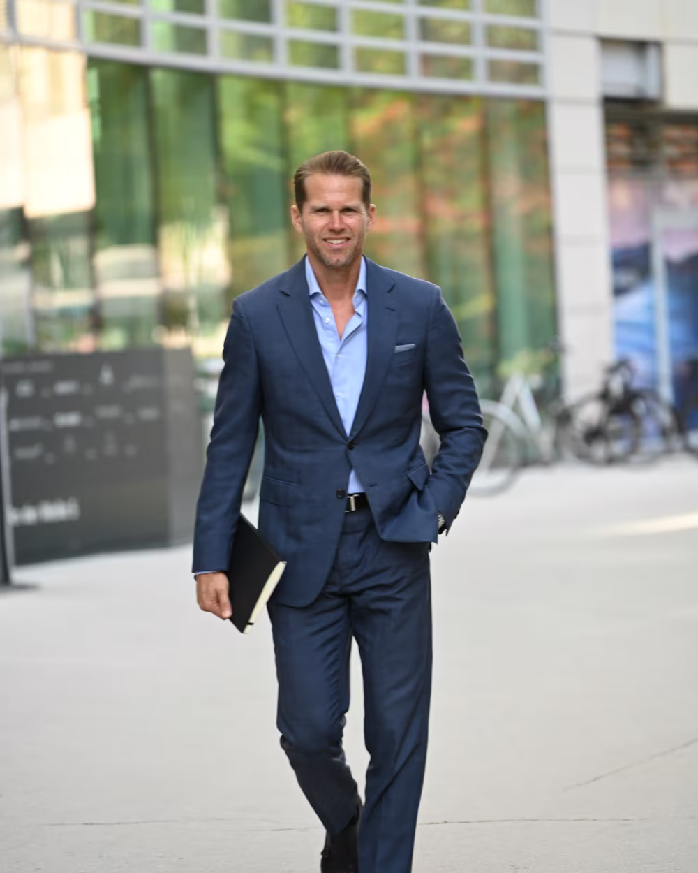 Norman Bartsch im dunkelblauen Anzug auf dem Weg durch das Frankfurter Bankenviertel.